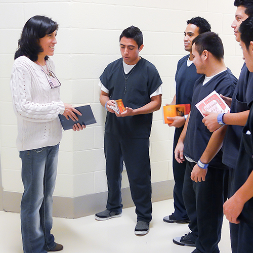 Esmeralda Saltos standing with young men prison inmates