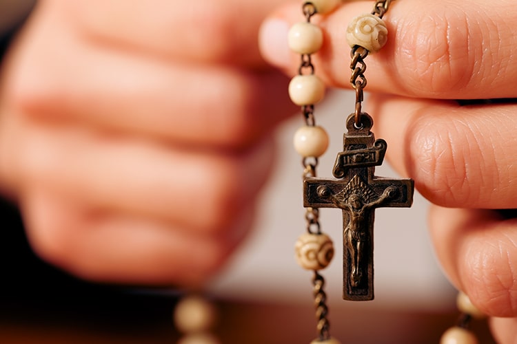 Close up of woman's hands holding rosary